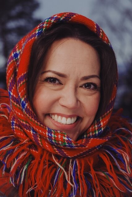 Bilde av Liv Natalie Nymo. Tatt av fotograf Arnar Aanes Bjorøy. Dame med rødt ullsjal rundt hodet som smiler