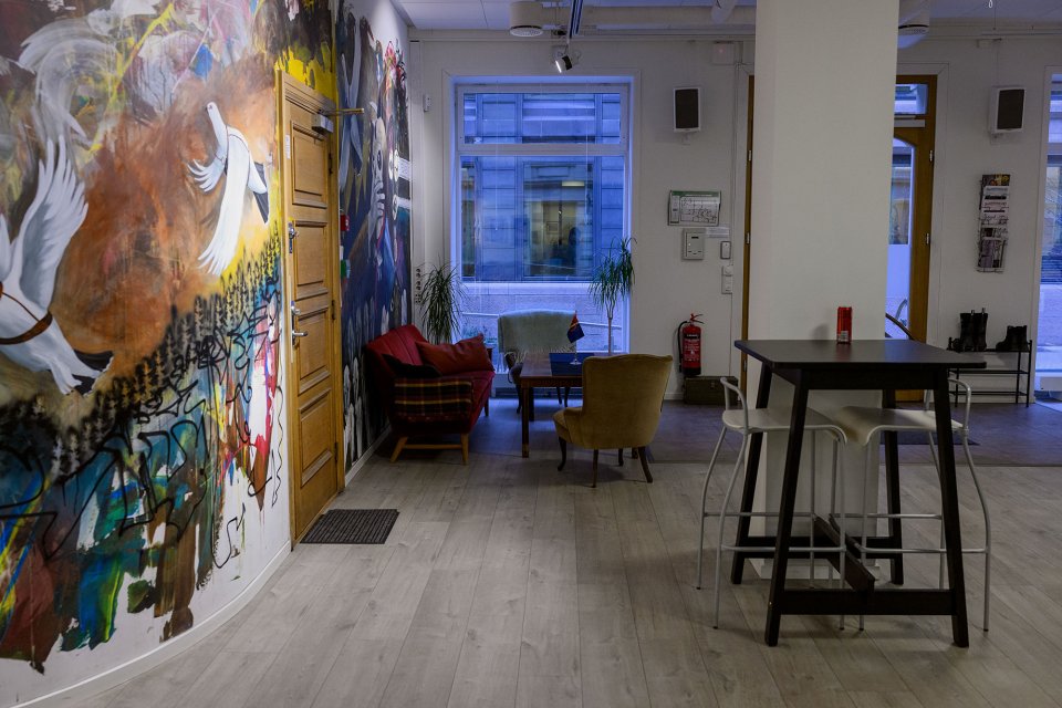 Veggmaleri og sittegruppe ved vinduet.