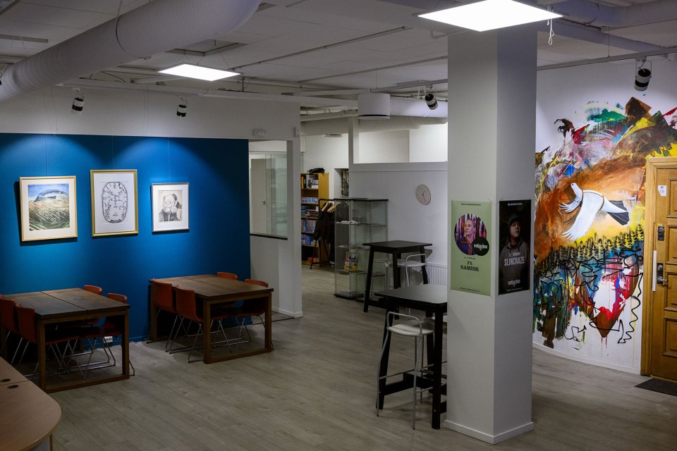 Interiør med blå vegg, bord og stoler