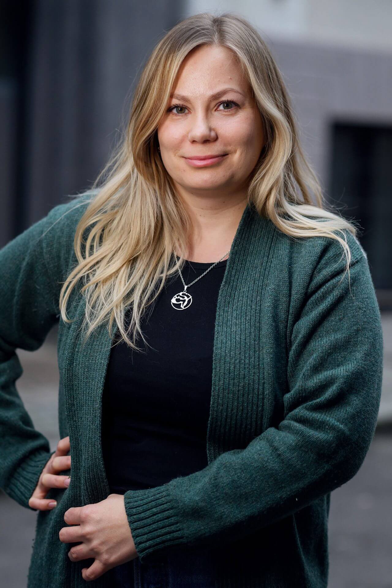 Kvinne med blondt langt hår og grønn strikkejakke